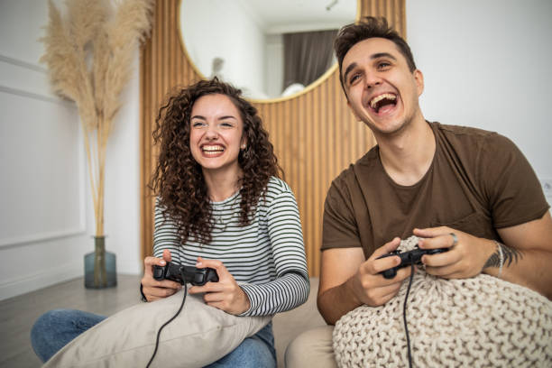 istock Young couple playing video games on console at home, having a good time 1437986828
