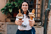 Woman holding two cones of organic italian ice cream