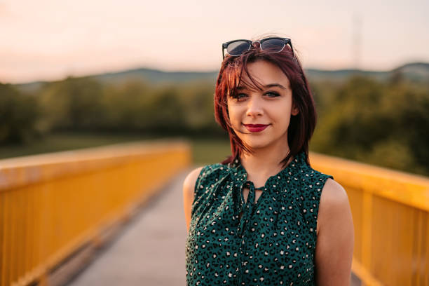 Portrait of a beautiful young woman outdoors on the bridge on a sunny day.