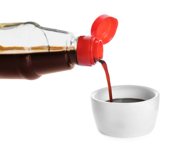 istock Pouring soy sauce into bowl against white background 1437988406