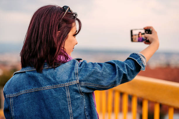 istock Young Woman Taking Selfies Using Smart Phone On The Yellow Bridge 1437988611