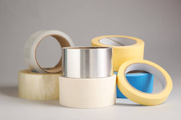 Many rolls of adhesive tape on light grey background