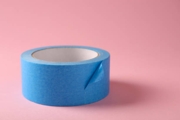 istock Roll of light blue adhesive tape on pink background. Space for text 1437989682