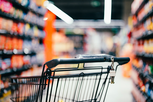 Shopping cart filled with groceries isolated on white background