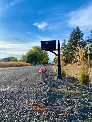 A mailbox with two American flags on a country dirt road in Southern Oregon.
