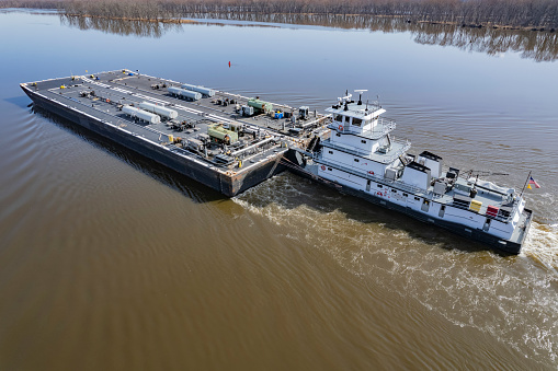 A towboat pushes fuel barges north on the Mississippi River
