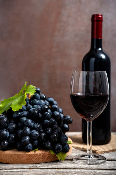 istock Red wine and grapes on wooden background 1437996438