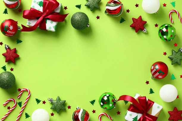 istock Christmas frame. Flat lay gift boxes, baubles, candy canes, confetti on pastel green background. Happy New Year greeting card template. 1437997235