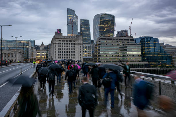 Blurred motion view of commuters with umbrellas in London going to work