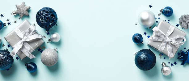 istock Christmas banner design. Blue Xmas background with blue and silver balls, gift boxes, confetti. Happy New Year header mockup. 1437998237