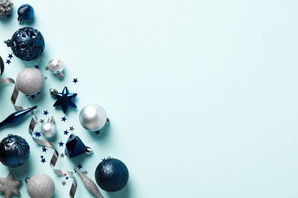 istock Top view blue and silver Christmas decorations, stars, balls, confetti on light blue background. Christmas frame, New Year greeting card template. 1437998272