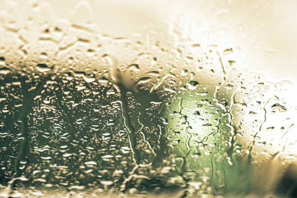 drops of rainwater running down glass
