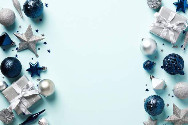 istock Blue Christmas background with baubles, silver gift boxes and stars decorations. Christmas frame. Top view. Flat lay. 1437998382