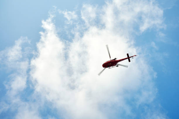 istock Helicopter in cloudy blue sky 1438001881