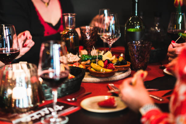 gente comiendo tapas en un bar de tapas con comida y bebidas en la mesa - spanish cuisine fotografías e imágenes de stock