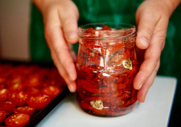 istock Woman in her kitchen preparing sun-dried tomatoes 1438002705