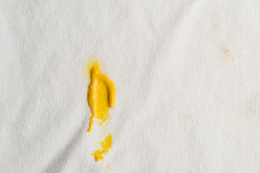 Macro photography of mustard stain on white fabric of cotton