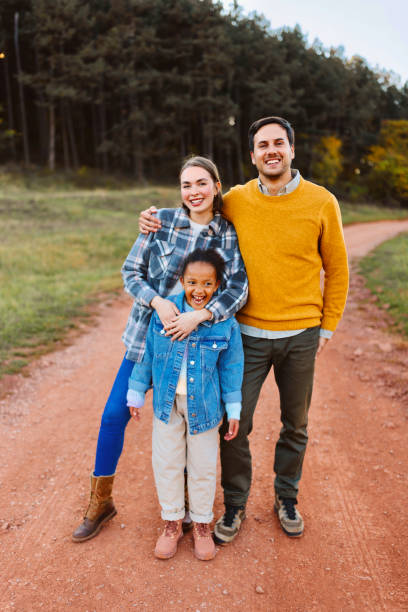 Portrait of a happy stepfamily on a hike Stepfather and stepmother bonding with stepdaughter during walk in a nature adaptation to nature stock pictures, royalty-free photos & images