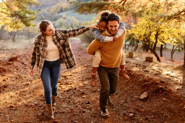 familia joven haciendo una caminata en el bosque - pareja acogido al aire libre fotografías e imágenes de stock
