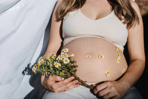istock Pregnant beauty holding flowers 1438006559