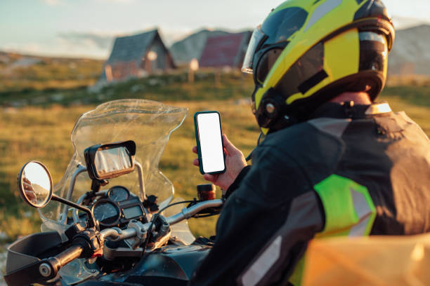 istock Biker sitting on motorbike and using phone 1438007642