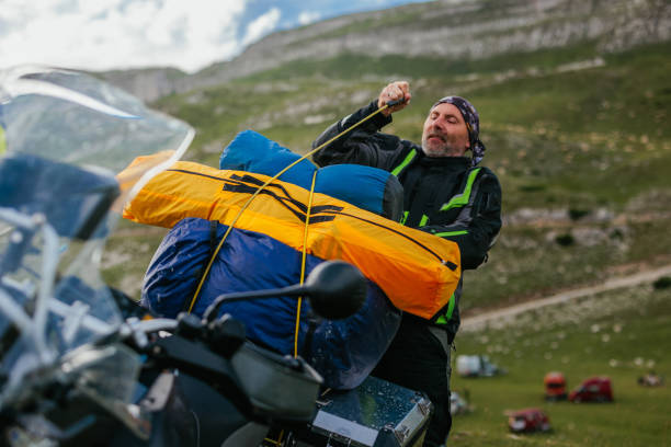 istock Biker packing up camping gear on bike 1438008207