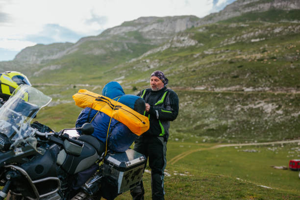 istock Biker packing up camping gear on bike 1438009773