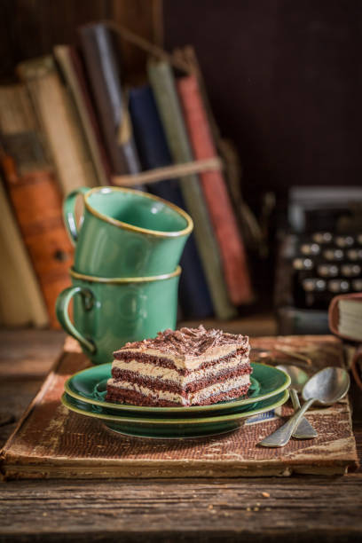 Chocolate cake and green coffee cups on writer desk
