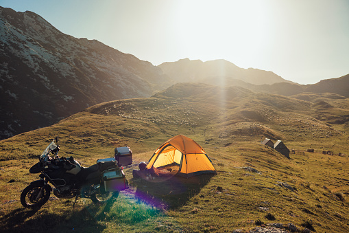 Motorcycle tent camping. Tent and motorcycles in the mountains. The camp environment is in the morning sun.