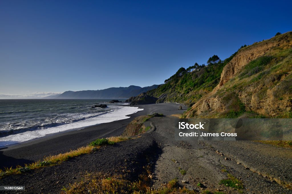 Black Sand Beach - Shelter Cove California This beautiful Black Sand beach is located on the North end of the Shelter Cove Peninsula.  You can literally hike for miles following the shoreline to the North.  Sneaker Waves also occur on this part of the West Coast. Beach Stock Photo