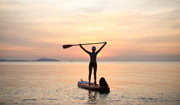 istock woman, dog, board, sea 1438019683