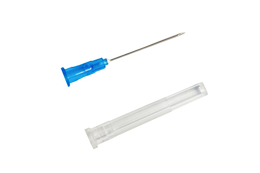 Parts of medical syringe: needle and cap isolated on white background.