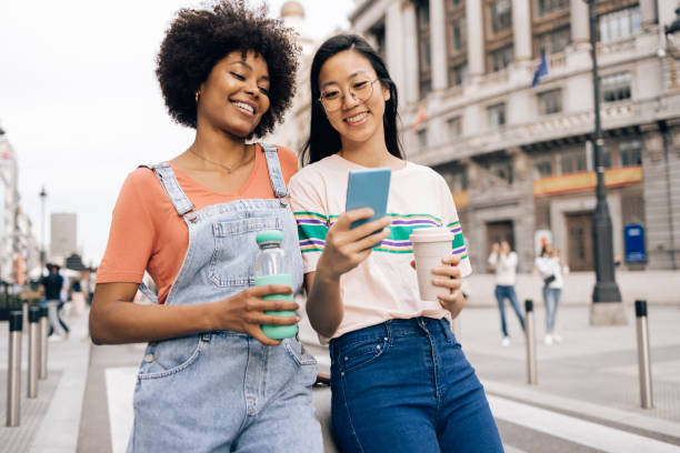 istock Two girlfriends on vacation  eating lollipops and having fun online 1438022928