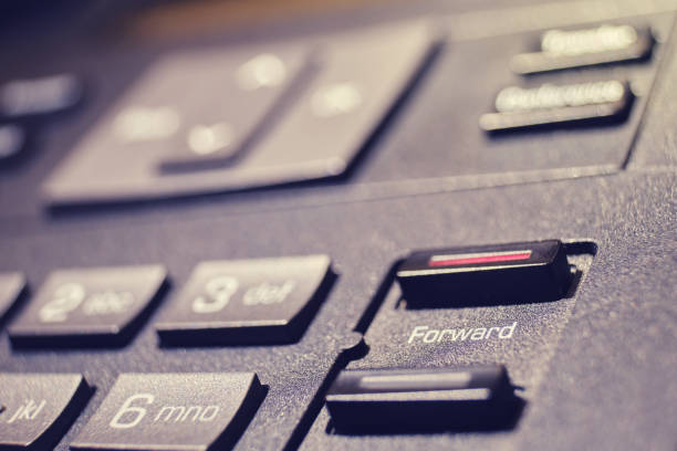 istock Button with text forward on a landline phone in the office, close-up 1438023276