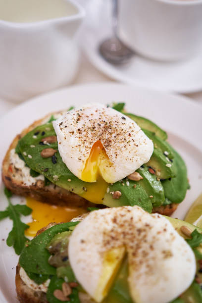 istock Freshly made poached egg and Avocado toasts on light grey background 1438023505