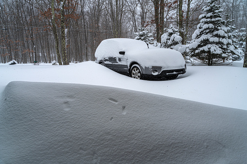A car covered by snow under snowfall