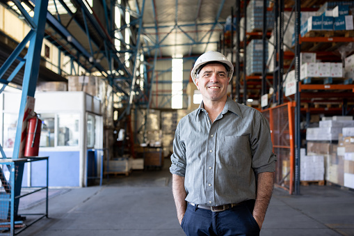 Portrait of a Latin American business man working on the logistics of a distribution warehouse and looking at the camera smiling