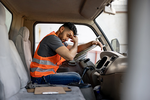Conductor de camión cansado que tiene dolor de cabeza después de trabajar horas extras photo