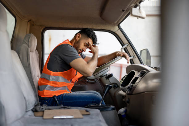 chauffeur de camion fatigué ayant mal à la tête après avoir travaillé des heures supplémentaires - fatigue photos et images de collection