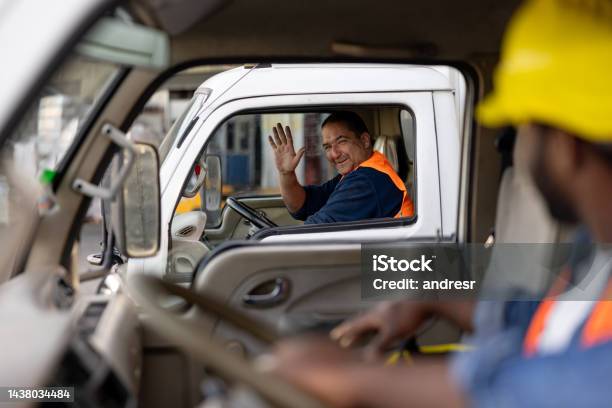 Happy Truck Driver Greeting Another One While Driving Stock Photo - Download Image Now