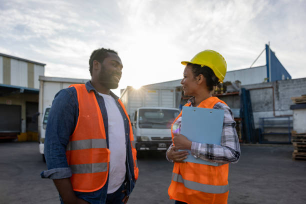 istock Supervisor talking to a happy truck driver at a distribution warehouse 1438034492
