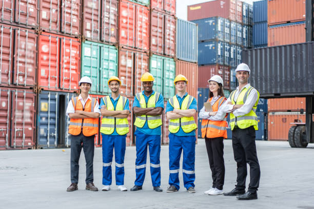 istock Portrait group of attractive worker people work in container terminal. Young handsome business man and woman stand with confidence after process orders at warehouse logistic in cargo freight ship. 1438035607
