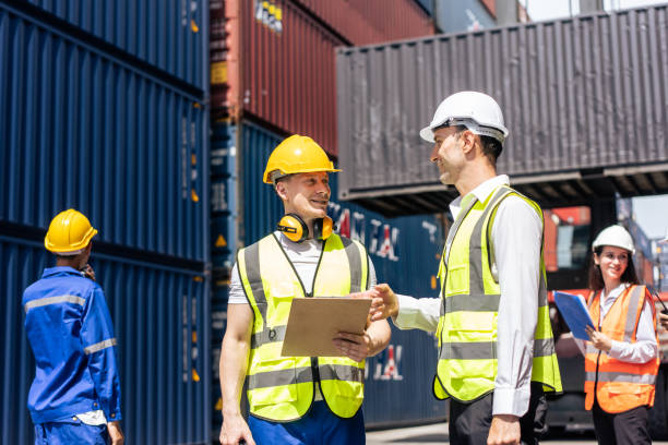istock Two Caucasian businessman worker work in container terminal together. Attractive male engineer people processes orders and product at warehouse logistic in cargo freight ship import export in harbor. 1438035616