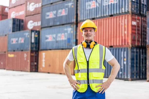 istock Portrait of Caucasian engineer worker work in container port terminal. Attractive foreman worker processes order and product at warehouse logistic in cargo freight ship for import and export in harbor 1438035617