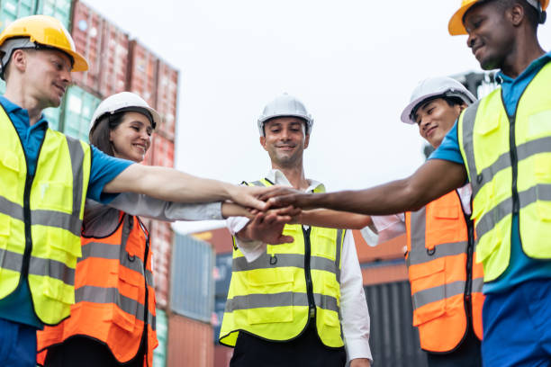 Group of man and woman worker put hand on each other in container port. Attractive young business woman and foreman feel happy after processes order success at warehouse logistic in cargo freight ship stock photo
