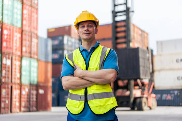 istock Portrait of Caucasian engineer worker work in container port terminal. Attractive foreman worker processes order and product at warehouse logistic in cargo freight ship for import and export in harbor 1438035704