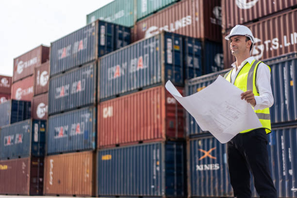 Caucasian handsome man engineer worker work in container port terminal. Young foreman worker processes order and products at warehouse logistic in cargo freight ship for import and export in harbor. trabajador de ingeniería guapo caucásico trabaja en la terminal portuaria de contenedores. joven capataz trabajador procesa pedidos y productos en la logística del almacén en el buque de carga para la importación y exportación en el puerto.