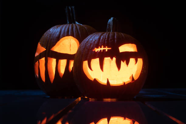 istock Twilight Jack O'Lanterns - Carved Pumpkins at Night - Scary Halloween Decorations - Close Up 1438036539
