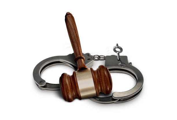 istock Judge gavel and handcuffs over white background 1438038434