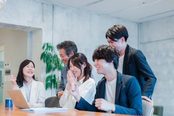 escritório de uma empresa de risco onde todos trabalham bem juntos - japanese ethnicity - fotografias e filmes do acervo